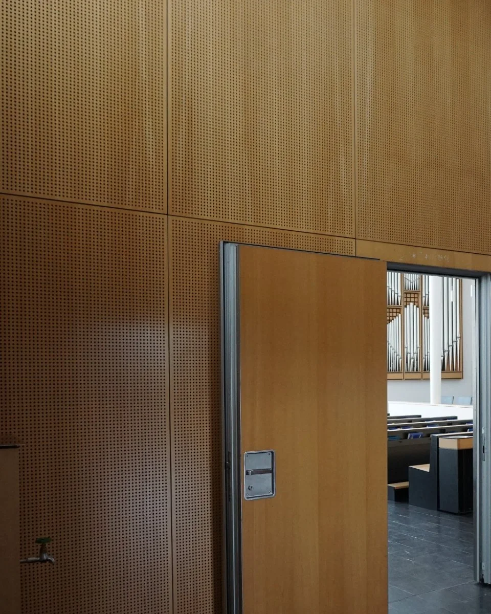Operable wall in perforated veneer with aluminium edging and an integrated pass door